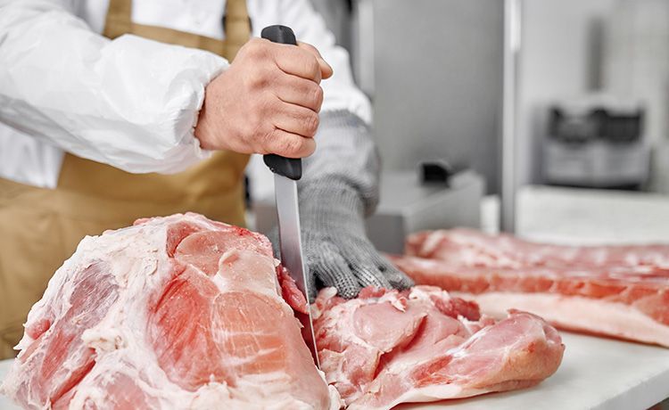Fleischer schneidet Fleisch.