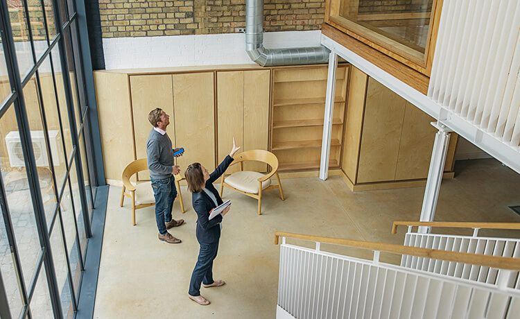 Ein Immobilienkaufmann und eine Immobilienkauffrau schauen sich zusammen eine Wohnung an.