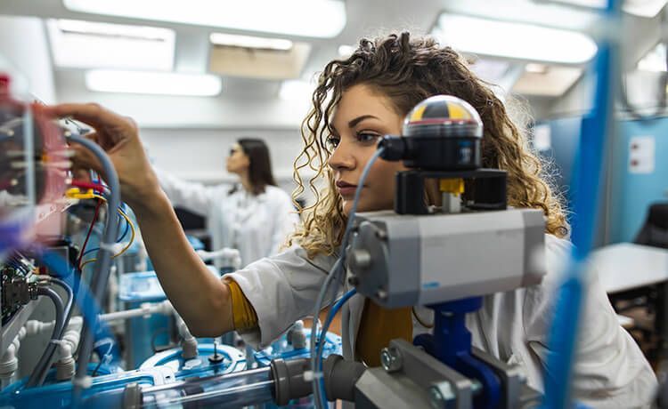 Junge Mechatronikerin arbeitet in einem mechanischen Labor.