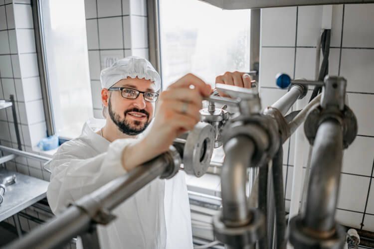 Milchtechnologe arbeitet an einer Maschine.