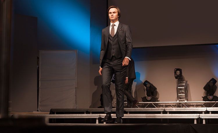 junger Mann im Anzug auf einem Laufsteg als Model junger Mann im Anzug auf einem Laufsteg als Model