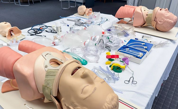 Tisch voll mit Beatmungspuppen und weitere Geräte, die angehenden Rettungssanitätern im Laufe der Ausbildung begegnen.