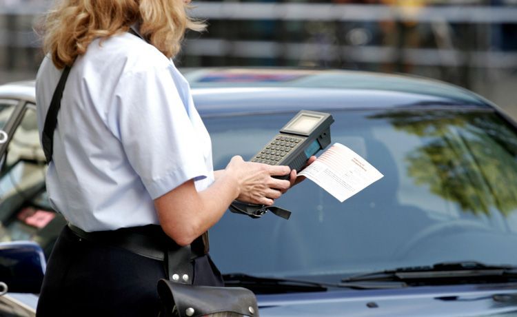 Verkehrsüberwacherin kontrolliert ein parkendes Auto Verkehrsüberwacherin kontrolliert ein parkendes Auto