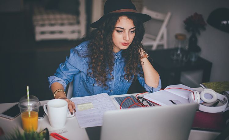Social Media Managerin sitzt an einem Schreibtisch und beantwortet Fragen von Usern.