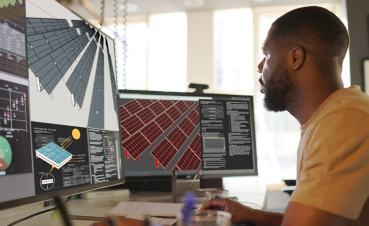 Junger Mann arbeitet am PC an technischen Plänen für eine Photovoltaik-Anlage.