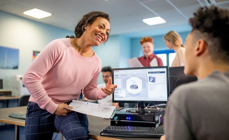 Ausbilderin erklärt Azubi in der Berufsschule technische Sachverhalte.