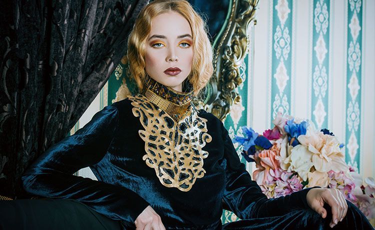 Model mit glamurösem Make-up posiert in elegantem Kleid Model mit glamurösem Make-up posiert in elegantem Kleid