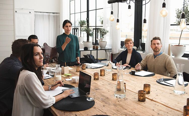 Mehrere Veranstaltungskaufleute sitzen an einem Tisch und besprechen ein Event.