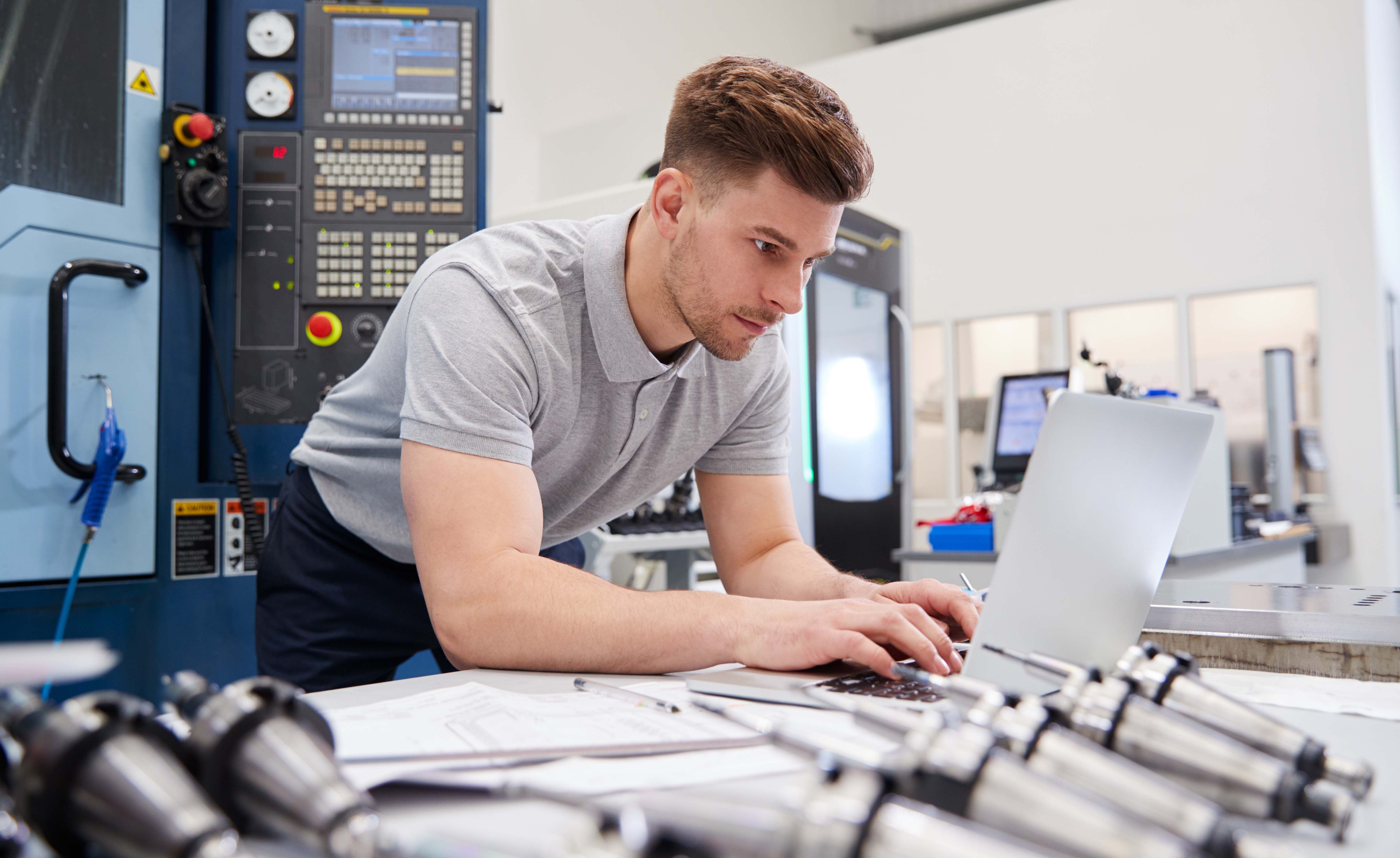 Kunststoff- und Kautschuktechnologe arbeitet am Laptop.