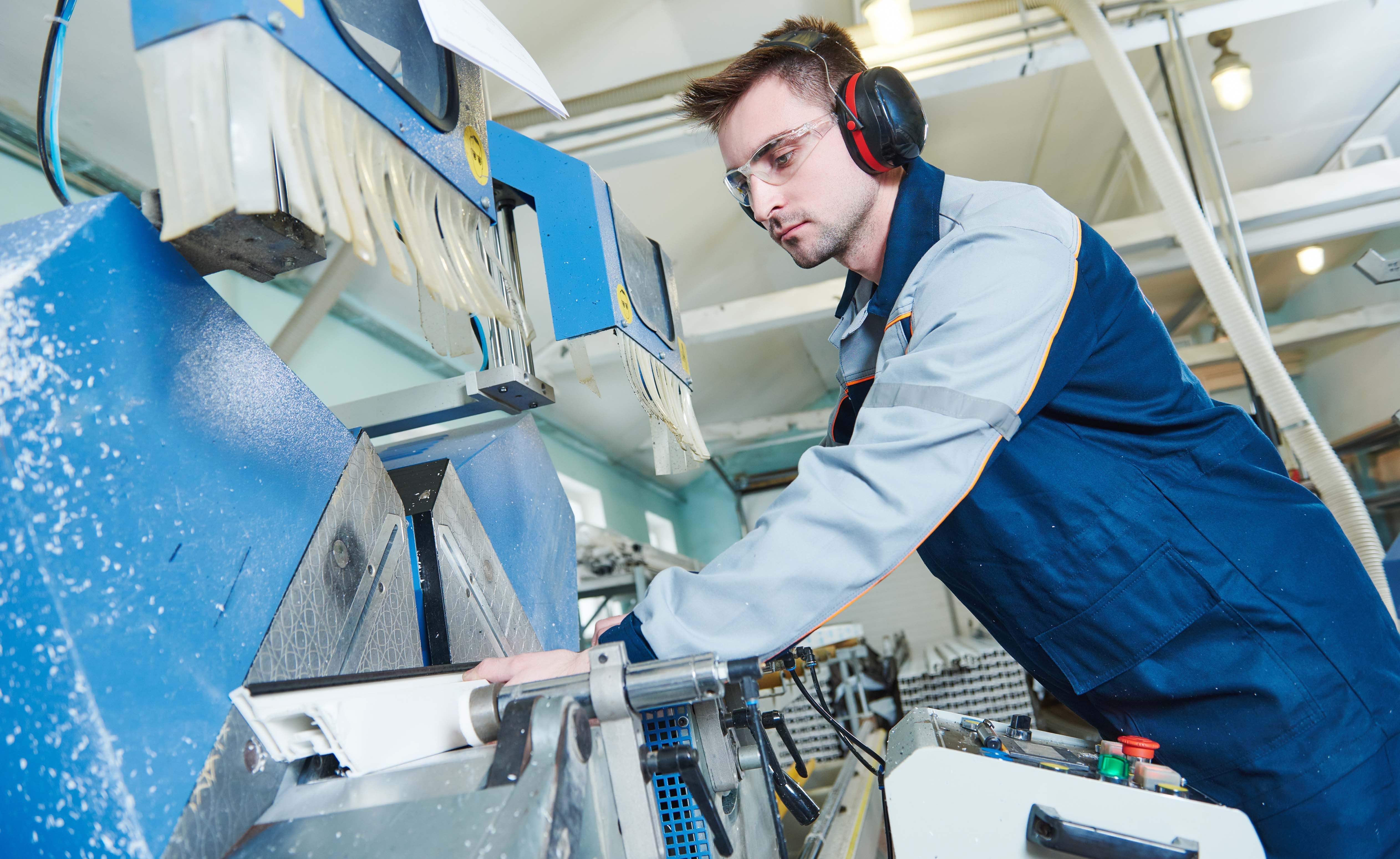 Kunststoff- und Kautschuktechnologe arbeitet an einer Maschine.