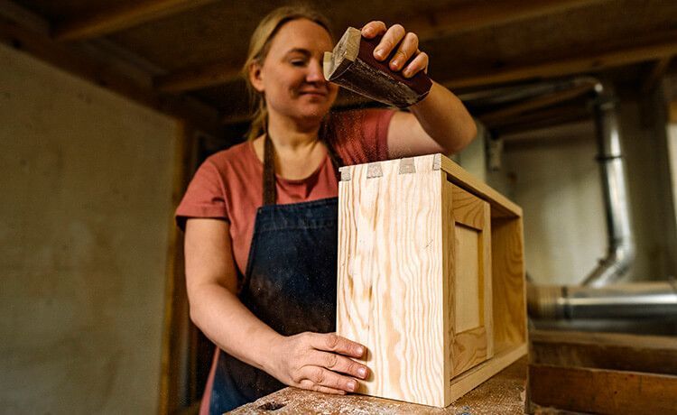Junge Zimmerin bearbeitet ein Holzbauteil. Junge Zimmerin bearbeitet ein Holzbauteil.