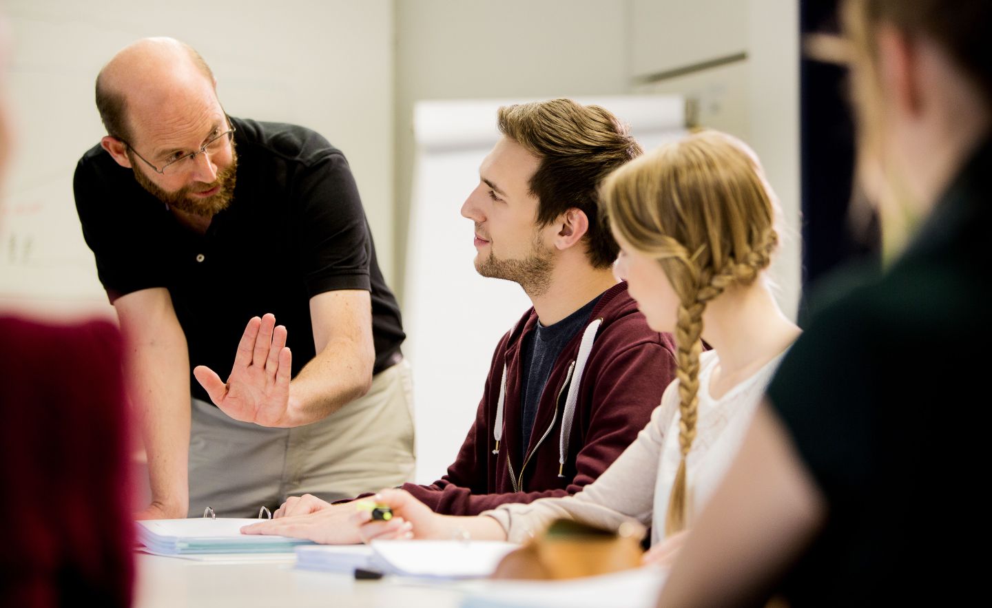 Lehrer erklärt Informatikstudenten den Lernstoff im Unterricht.
