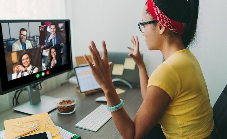 Junge Frau hat einen Videocall mit anderen Leuten.