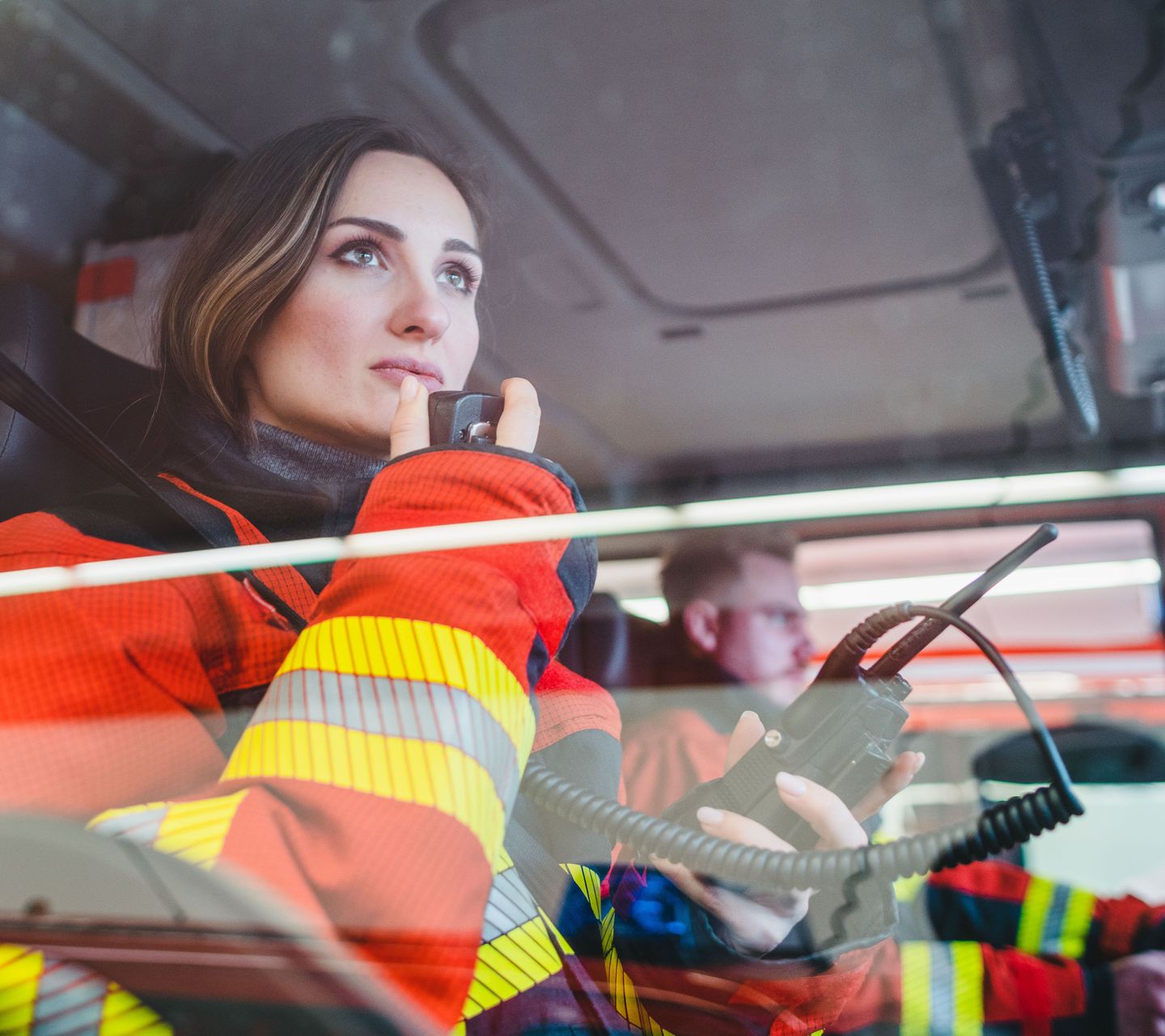 Feuerwehrfrau im Auto gibt einen Funkspruch durch.