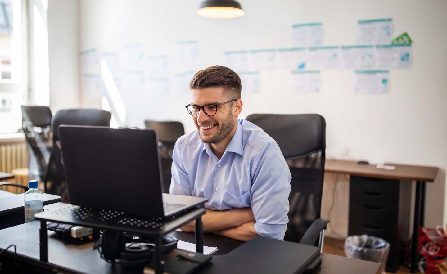 Ein Mann mit Hemd hat ein Online-Meeting im Büro.