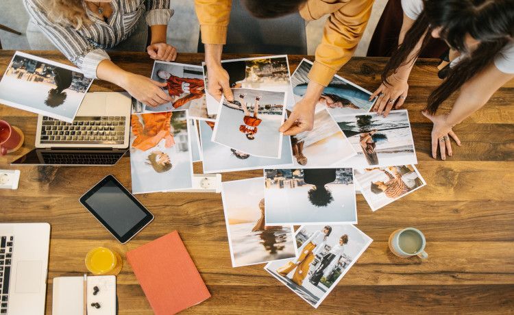 Mediengestalterinnen Digital und Print wählen Bilder aus.