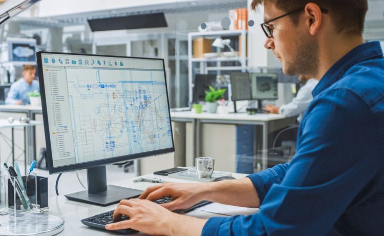 Bauzeichner erstellt mit CAD-Programm am Rechner einen Bauplan.