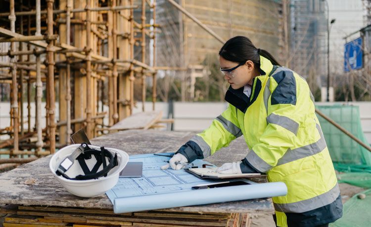 Eine junge Bauzeichnerin auf einer Baustelle