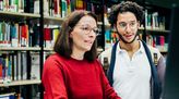Bibliothekarin hilft einem Nutzer der Bibliothek.