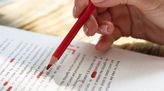 Lektorin korrigiert einen Text mit einem Stift.