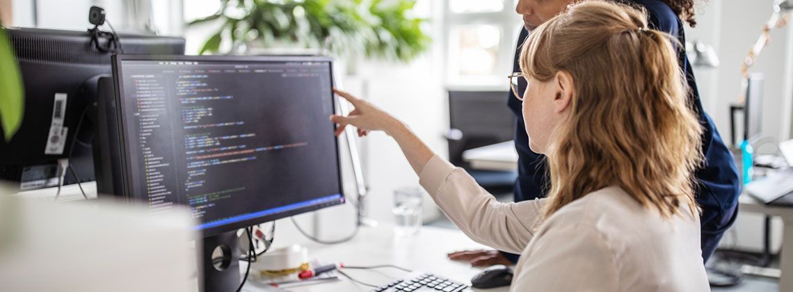 Eine Fachinformatikerin mit ihrem Kollegen bei der Arbeit am Rechner