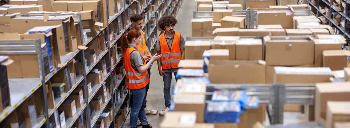 Fachkräfte für Lagerlogistik stehen im Lager und besprechen sich.